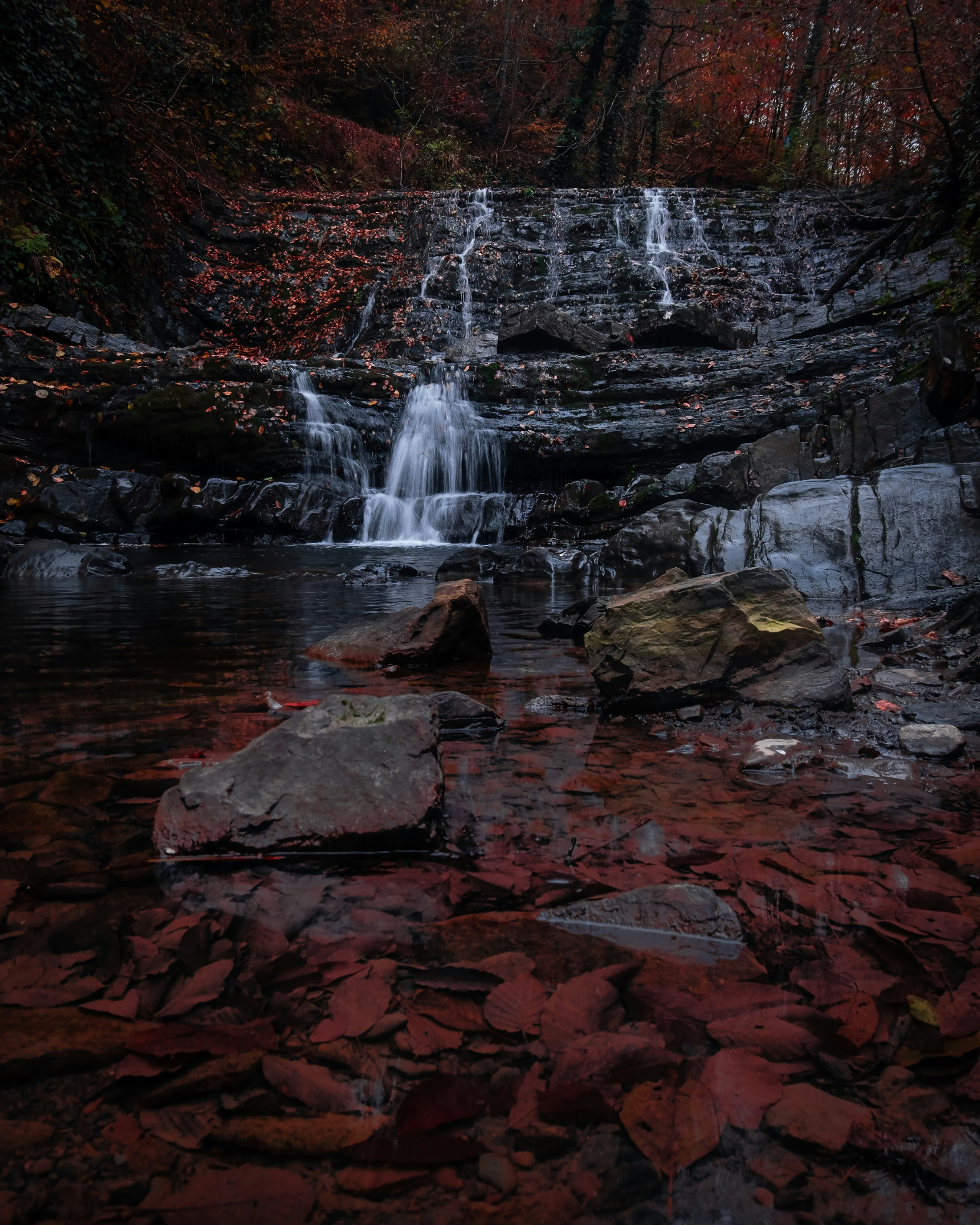 water falls on rocky shore during daytime